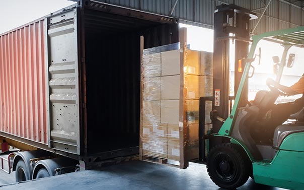 forklift Loading Package Boxes into Cargo Container